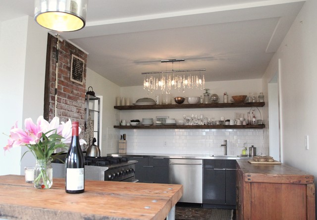 Example of a mountain style kitchen design in Vancouver with stainless steel appliances, subway tile backsplash, open cabinets, black cabinets, white backsplash and stainless steel countertops