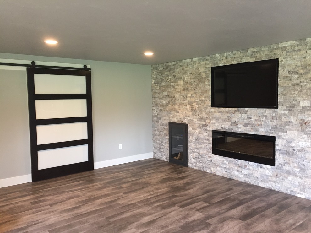 Basement - transitional walk-out vinyl floor and multicolored floor basement idea with gray walls, a standard fireplace and a stone fireplace