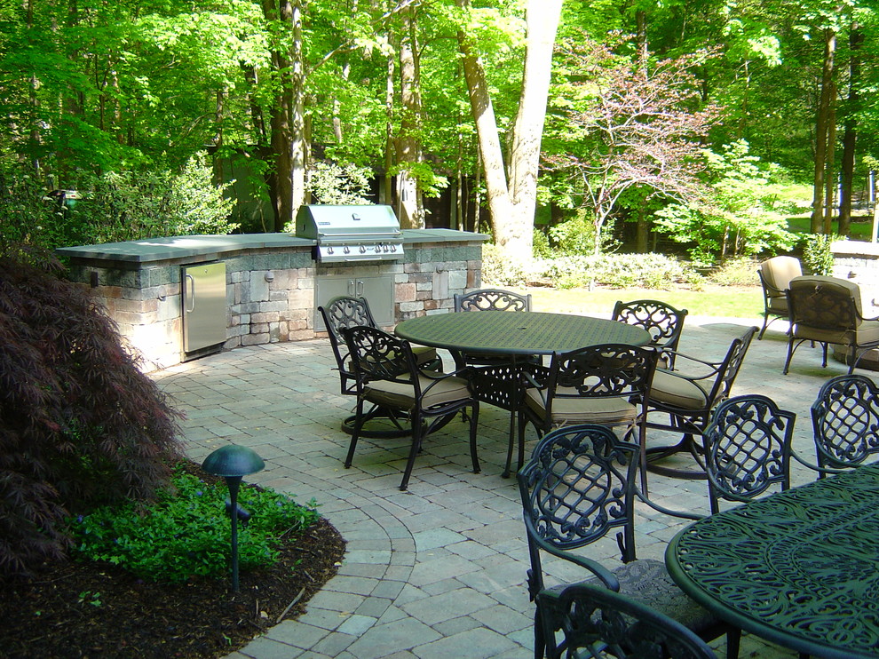 Mid-sized arts and crafts backyard patio in New York with an outdoor kitchen, concrete pavers and no cover.