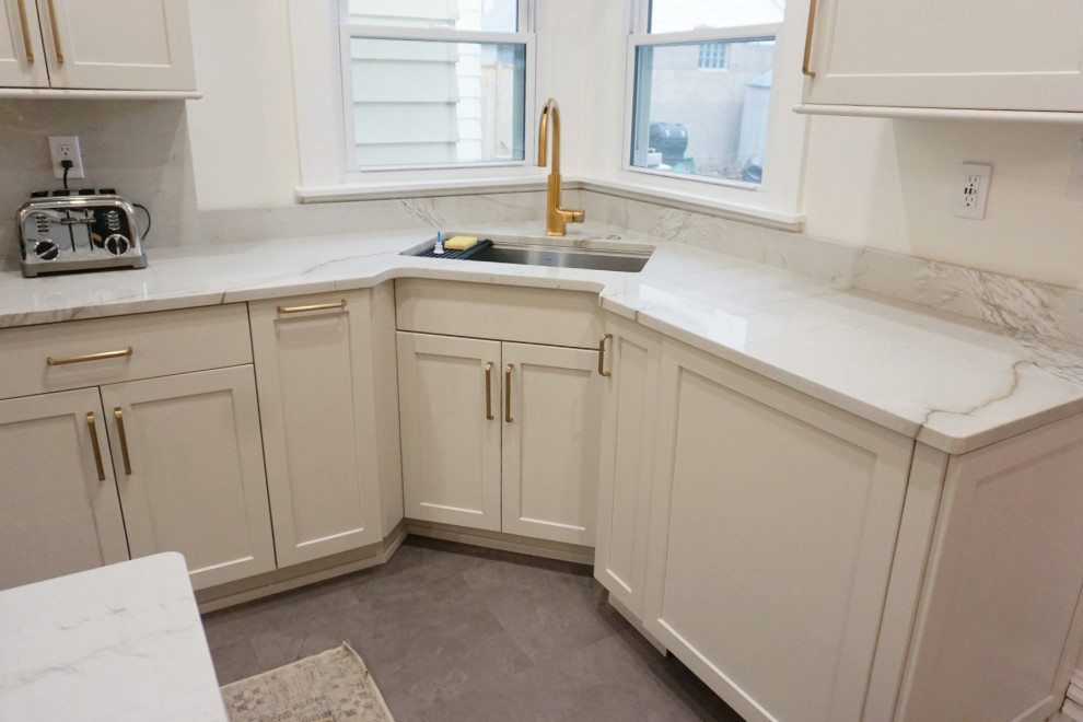 Kitchen - transitional vinyl floor and gray floor kitchen idea with an undermount sink, shaker cabinets, gray cabinets, quartzite countertops, stone slab backsplash, stainless steel appliances and an island