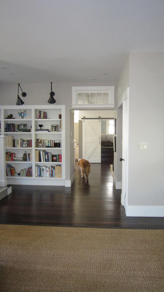 Photo of a mid-sized transitional open concept living room in San Francisco with a library, beige walls, dark hardwood floors, no fireplace and brown floor.