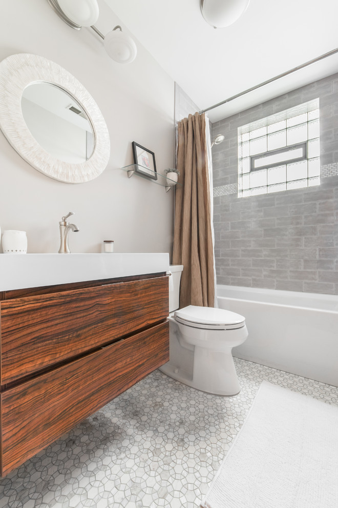 Design ideas for a mid-sized contemporary master bathroom in Chicago with a corner tub, a shower/bathtub combo, a one-piece toilet, gray tile, ceramic tile, grey walls, mosaic tile floors, a drop-in sink and a shower curtain.