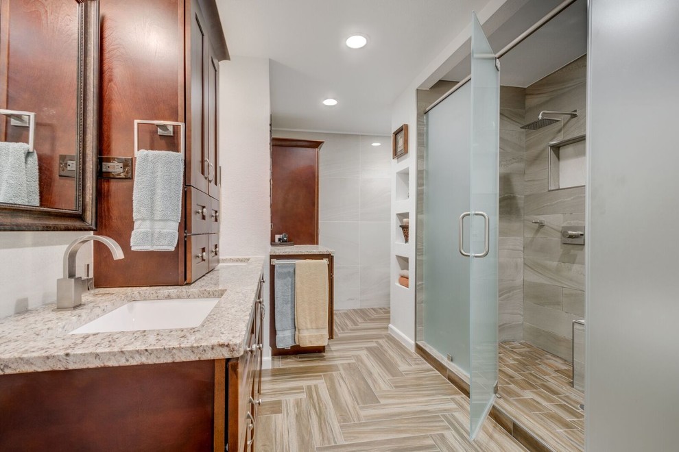 Design ideas for a large contemporary master bathroom in Dallas with raised-panel cabinets, medium wood cabinets, a corner shower, beige tile, white walls, ceramic floors, a drop-in sink and granite benchtops.
