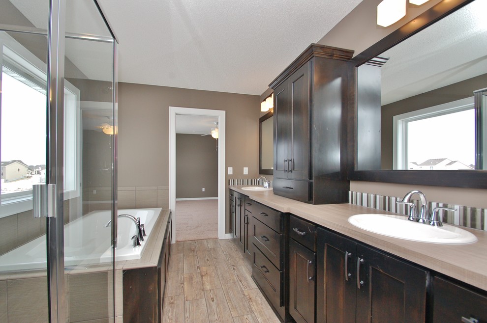 Mid-sized master bathroom in Minneapolis with a drop-in sink, shaker cabinets, dark wood cabinets, laminate benchtops, a drop-in tub, a corner shower, beige tile, ceramic tile, grey walls and ceramic floors.
