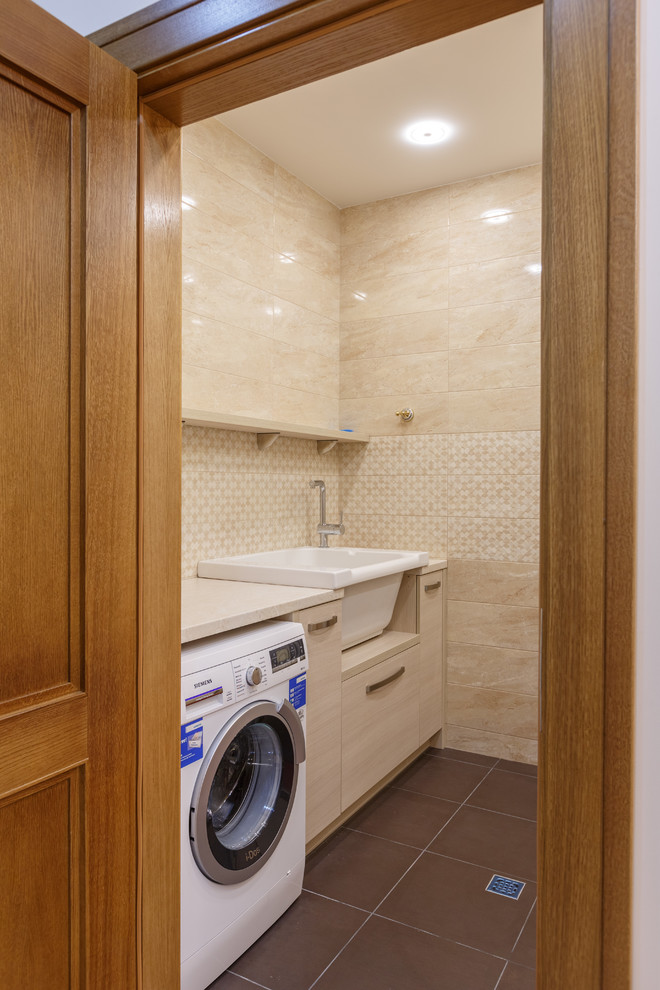 This is an example of a small traditional galley dedicated laundry room in Other with an utility sink, beaded inset cabinets, beige cabinets, granite benchtops, beige walls, porcelain floors, a side-by-side washer and dryer, brown floor and beige benchtop.
