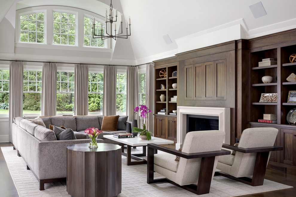 Traditional open concept family room in New York with dark hardwood floors, a standard fireplace and a concealed tv.