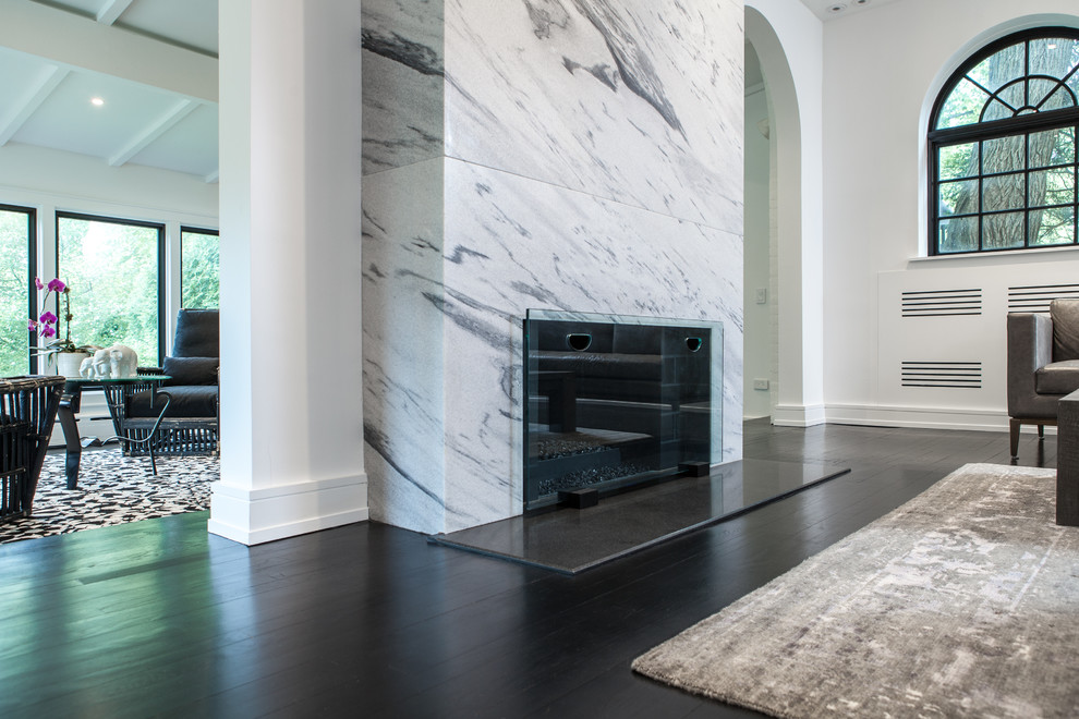 Inspiration for a large modern formal enclosed living room in Chicago with white walls, dark hardwood floors, a standard fireplace, a stone fireplace surround, a wall-mounted tv and black floor.