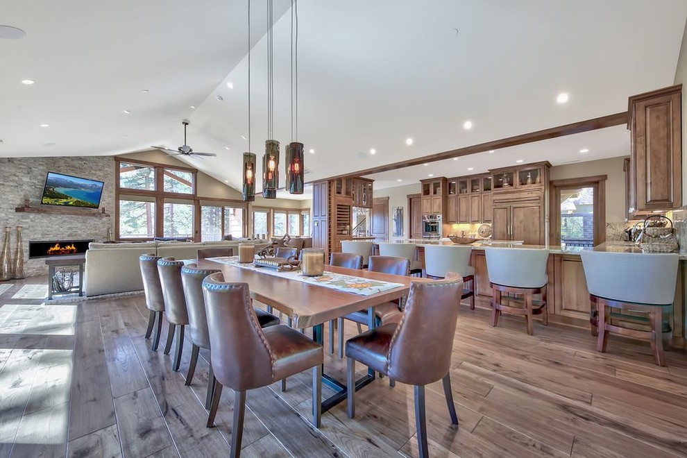 Great room - large transitional medium tone wood floor and multicolored floor great room idea with gray walls, a ribbon fireplace and a stone fireplace