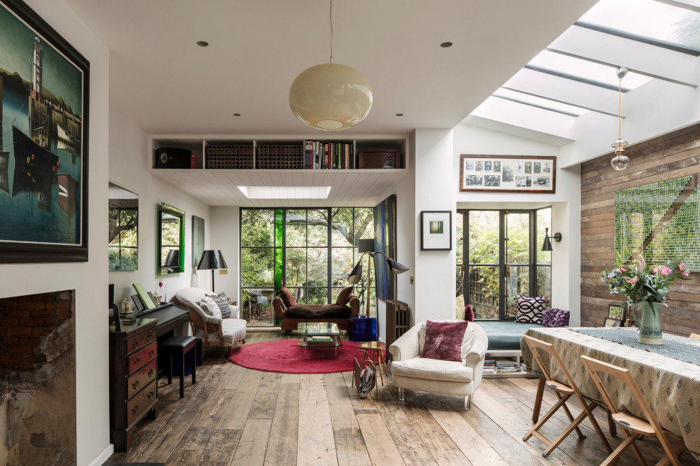 Inspiration for an eclectic open concept living room in London with brown walls, medium hardwood floors and brown floor.