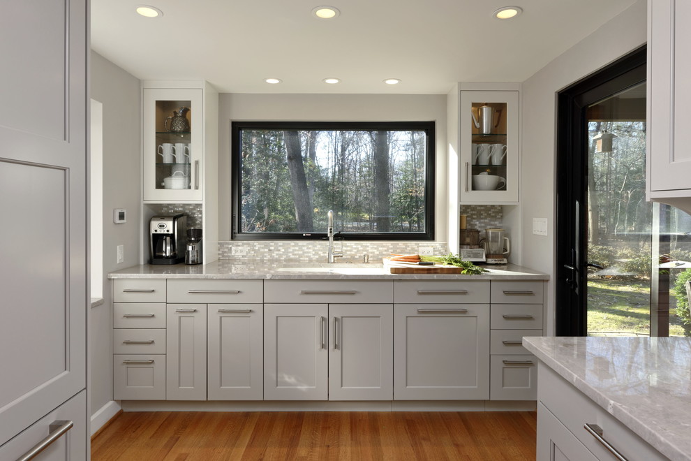 Large transitional galley medium tone wood floor and brown floor eat-in kitchen photo in DC Metro with an undermount sink, shaker cabinets, gray cabinets, quartzite countertops, gray backsplash, mosaic tile backsplash, stainless steel appliances, a peninsula and gray countertops