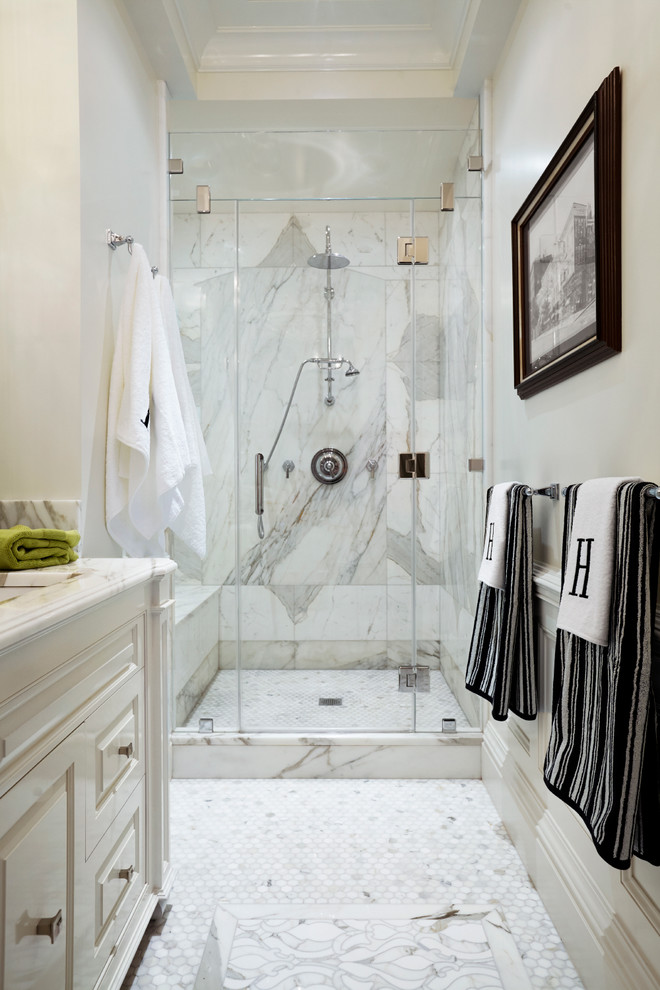 Inspiration for a small traditional 3/4 bathroom in New York with raised-panel cabinets, white cabinets, an alcove shower, white tile, stone slab, white walls, marble floors, an undermount sink and marble benchtops.
