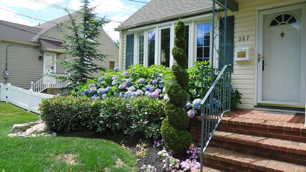 This is an example of a mid-sized front yard full sun garden in Philadelphia with a garden path and brick pavers.