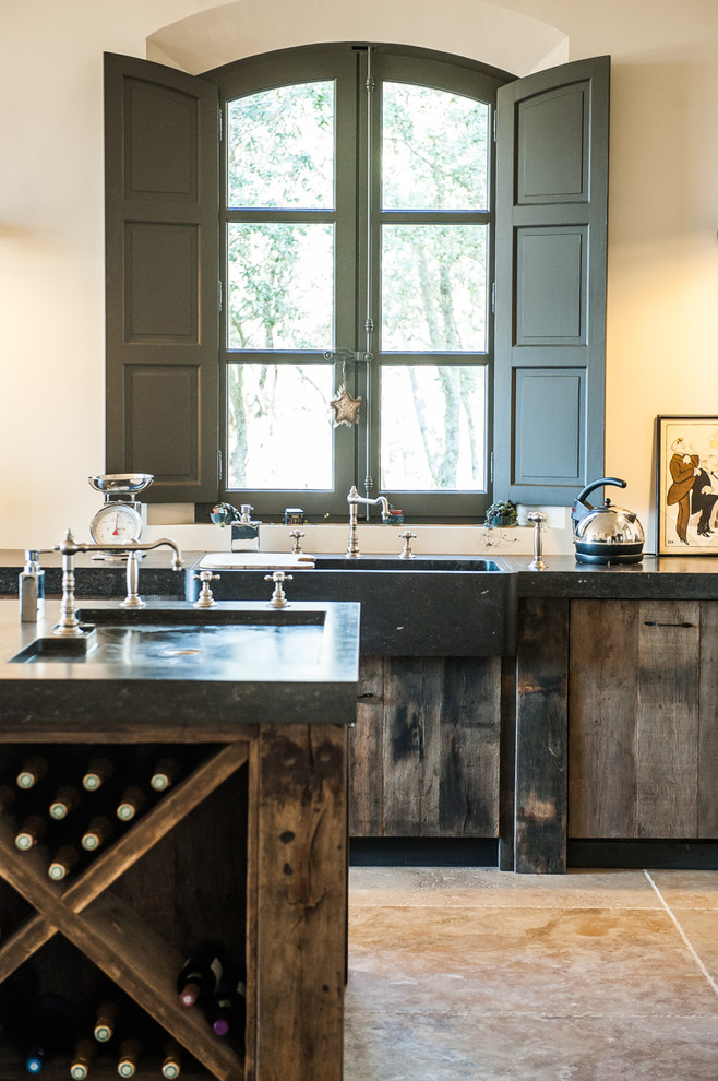 Photo of an expansive contemporary galley eat-in kitchen in Other with distressed cabinets, with island, a drop-in sink, granite benchtops, mirror splashback, black appliances, travertine floors, beige floor and grey benchtop.
