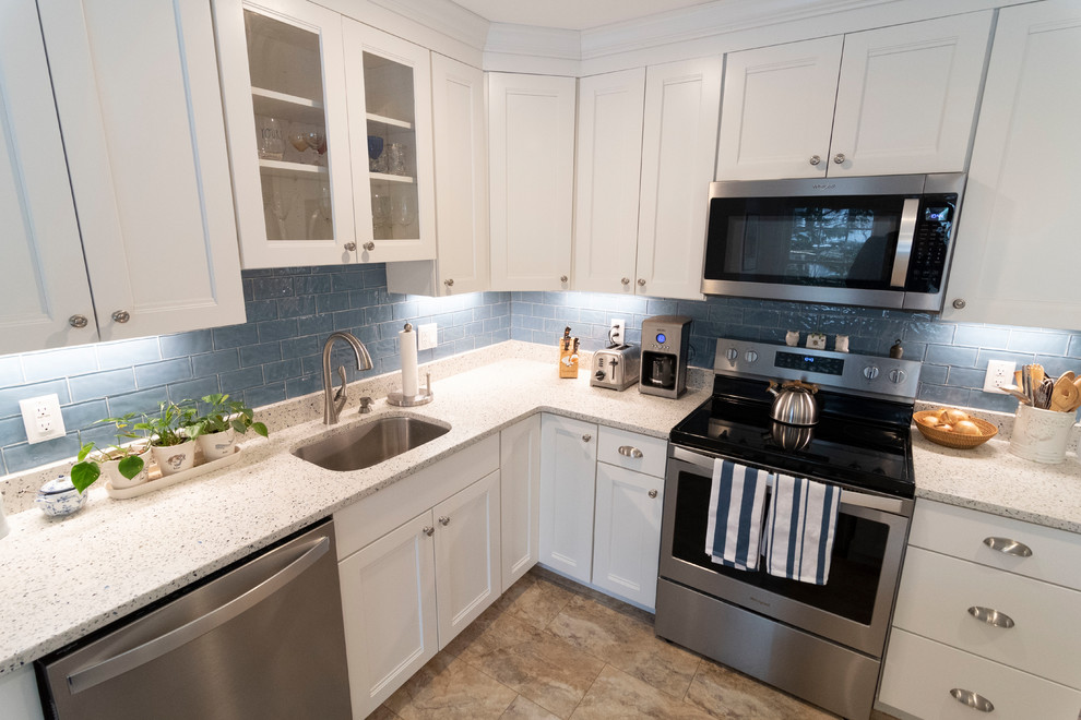 Enclosed kitchen - mid-sized transitional u-shaped beige floor enclosed kitchen idea in Boston with an undermount sink, recessed-panel cabinets, white cabinets, blue backsplash, subway tile backsplash, stainless steel appliances, an island and beige countertops