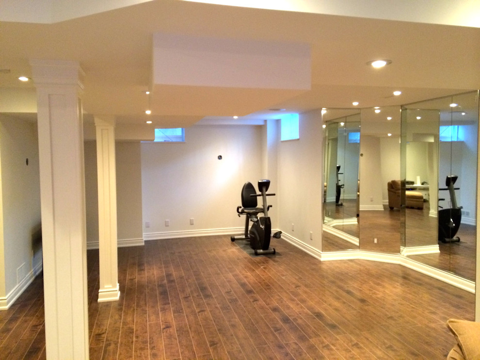 Example of a mid-sized classic medium tone wood floor home gym design in Toronto with beige walls
