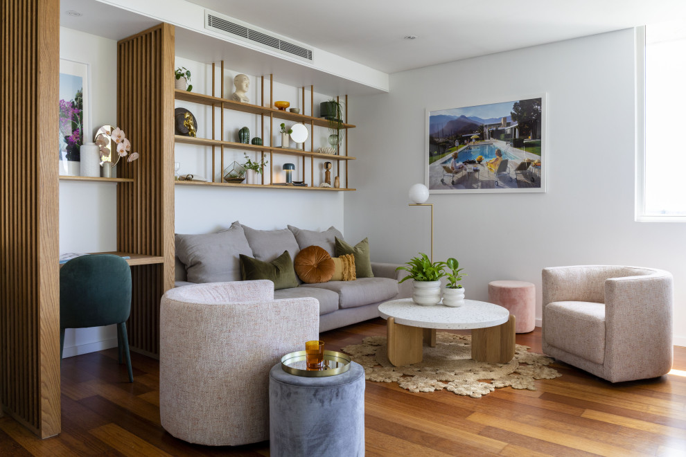 Immagine di un piccolo soggiorno tropicale aperto con pareti bianche, pavimento in legno massello medio e pavimento marrone