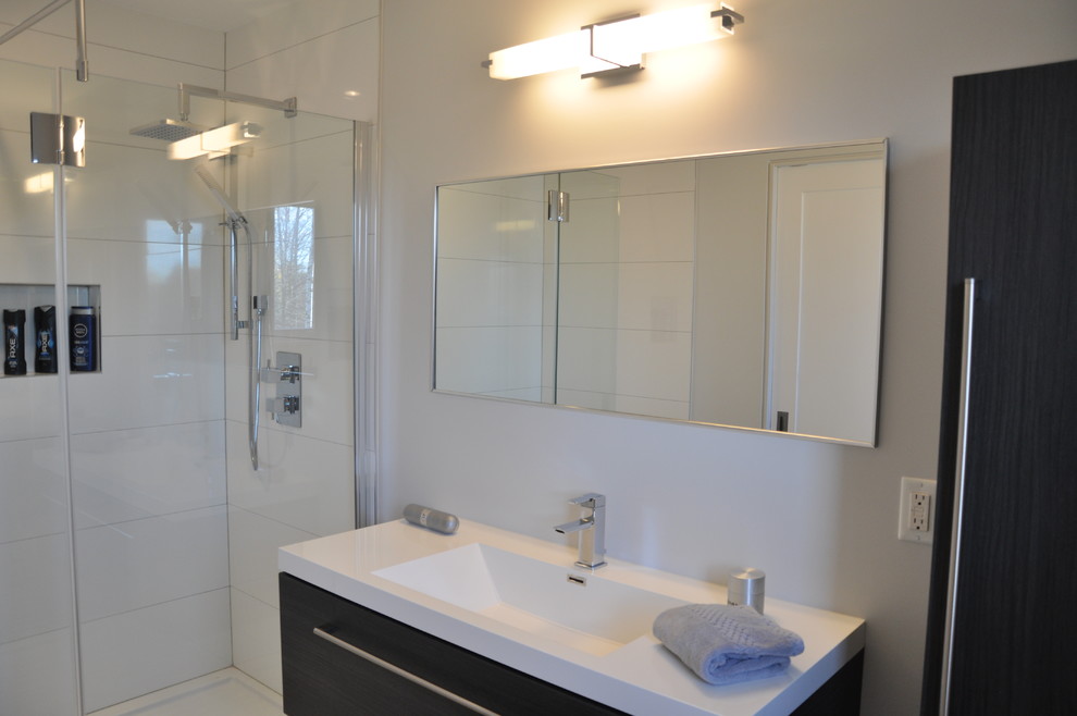This is an example of a large modern master bathroom in Toronto with an undermount sink, raised-panel cabinets, dark wood cabinets, granite benchtops, a drop-in tub, an open shower, a one-piece toilet and ceramic tile.