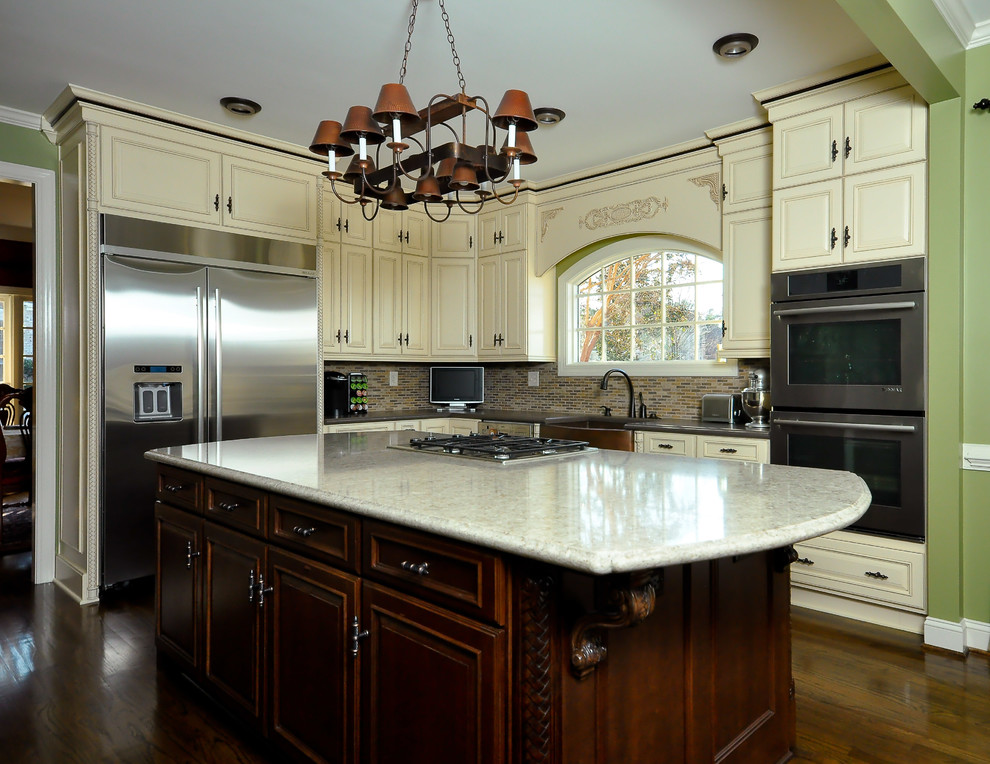 Mid-sized transitional l-shaped dark wood floor eat-in kitchen photo with a farmhouse sink, raised-panel cabinets, white cabinets, granite countertops, multicolored backsplash, mosaic tile backsplash, stainless steel appliances and an island