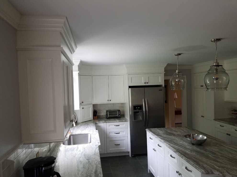 Example of a large transitional dark wood floor eat-in kitchen design in Boston with recessed-panel cabinets, white cabinets, granite countertops, multicolored backsplash, subway tile backsplash, stainless steel appliances and an island