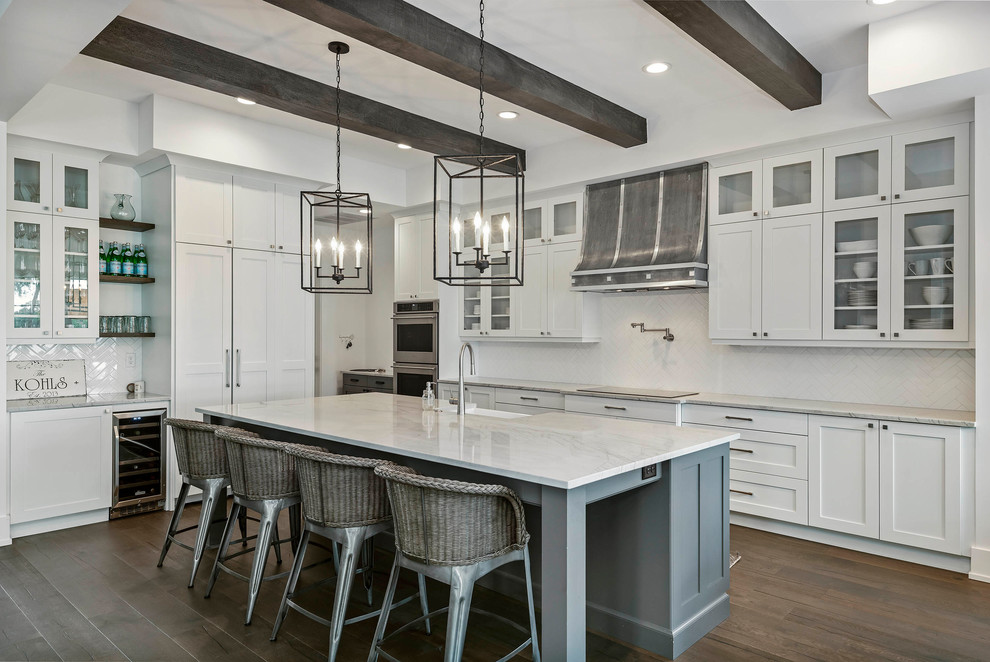 Inspiration for a large transitional l-shaped kitchen in Orlando with a farmhouse sink, white cabinets, marble benchtops, white splashback, with island, shaker cabinets, panelled appliances, dark hardwood floors, brown floor and white benchtop.
