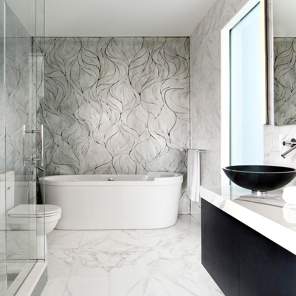 Inspiration for a mid-sized contemporary master bathroom in New York with a vessel sink, flat-panel cabinets, dark wood cabinets, marble benchtops, a freestanding tub, a two-piece toilet, white tile, mosaic tile, yellow walls and marble floors.
