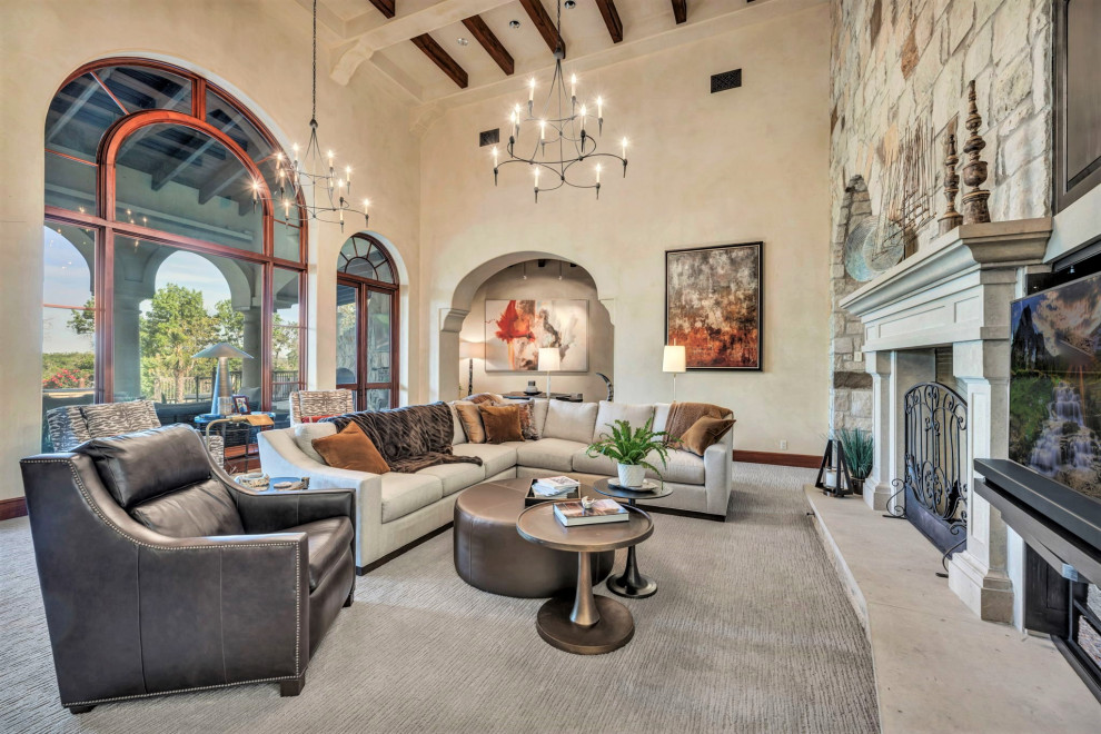 Photo of a large mediterranean living room in Austin with carpet, a standard fireplace and a concrete fireplace surround.