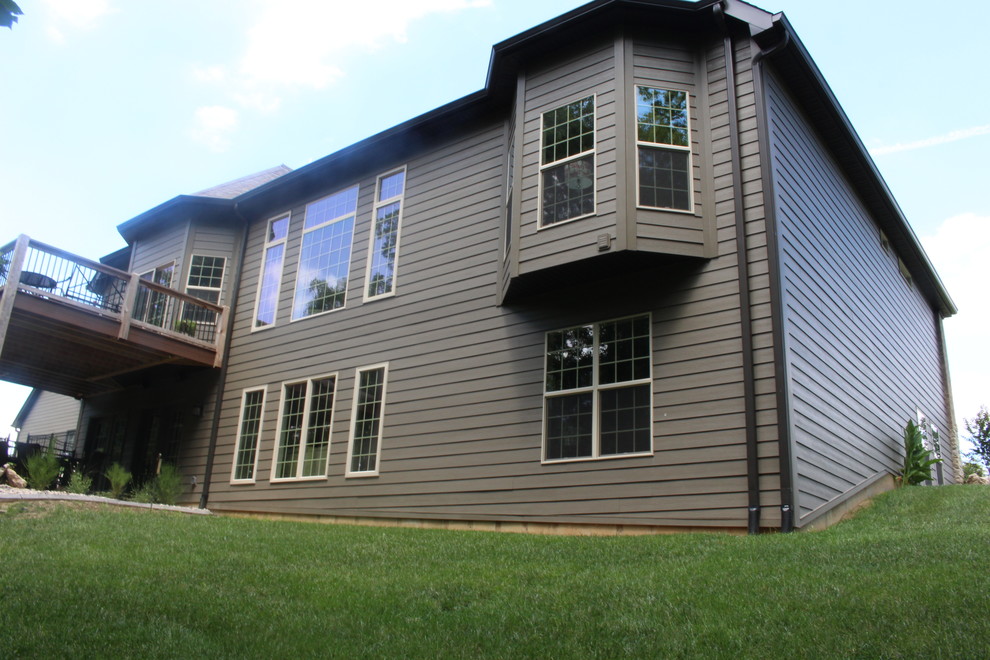 This is an example of a large country one-storey brown house exterior in St Louis with concrete fiberboard siding, a hip roof and a shingle roof.