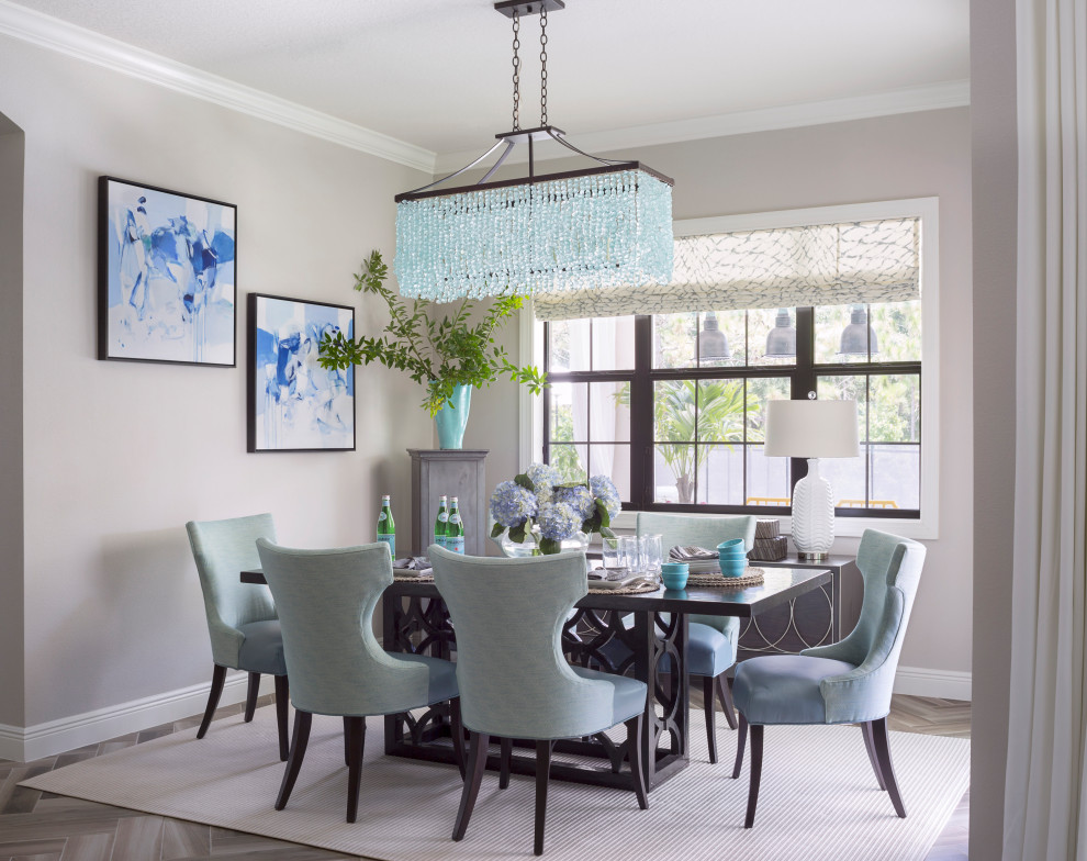 Bright and Sunny Breakfast Room - This open concept breakfast area off the kitchen is the hardest working room in the house.  The show stopping sea glass chandelier sparkles as light streams in the windows overlooking the pool area.  A pair of original abstract artwork in blue and white adorn the space. We mixed Sunbrella outdoor fabric chairs with leather seats that can be wiped off when the inevitable spill happens.  An outdoor rug hides crumbs while standing up the wet feet tracking in from the adjacent patio and pool area.
