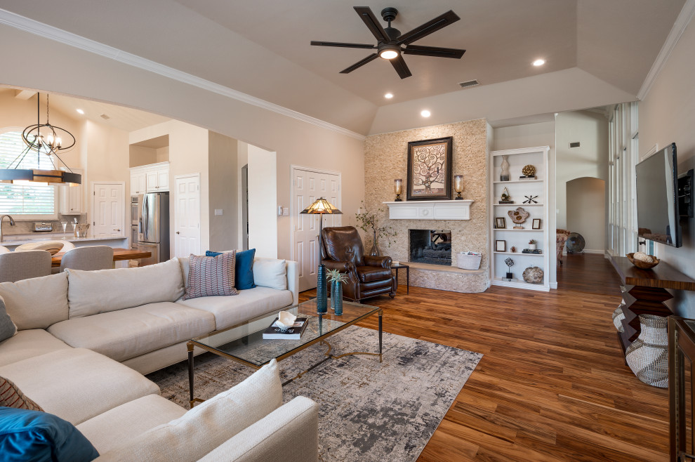 Klassisches Wohnzimmer mit Kamin, TV-Wand und braunem Boden in Dallas