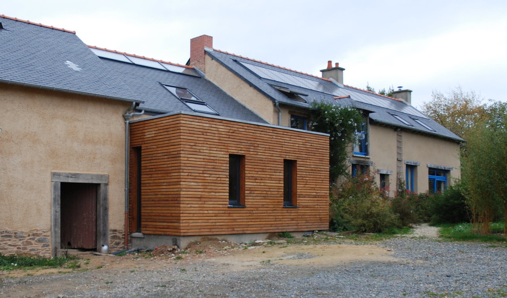 Cette image montre façade de maison in adobe With un toit à deux pans and un toit mixte.