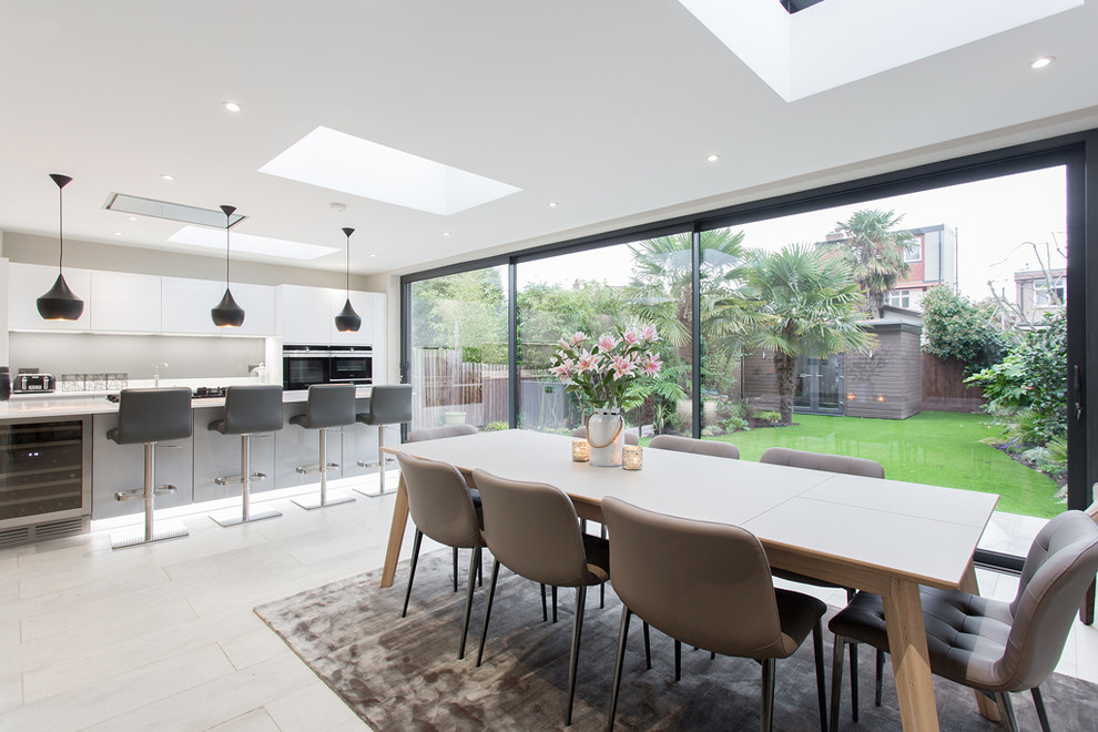 Inspiration for a mid-sized modern kitchen/dining combo in London with white walls and white floor.