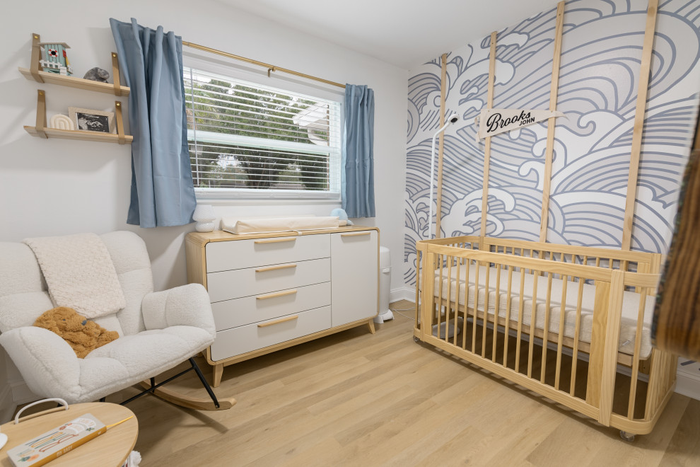 Imagen de habitación de bebé neutra costera de tamaño medio con paredes blancas, suelo vinílico, suelo beige y bandeja
