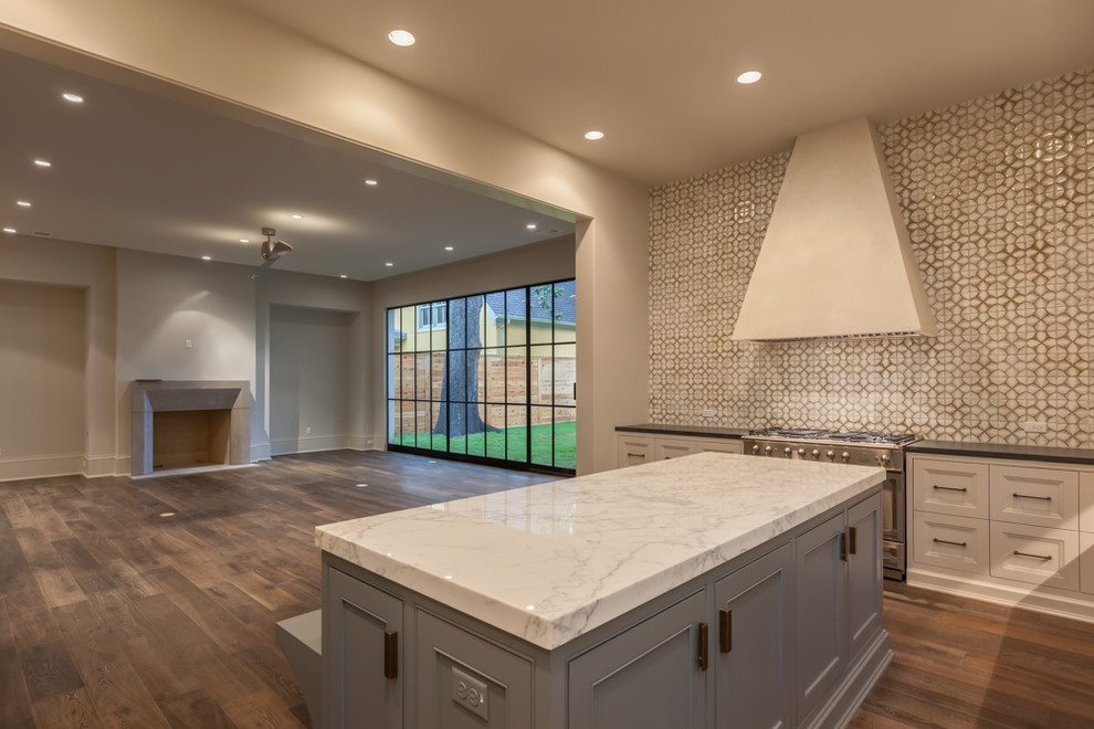 Inspiration for a large transitional l-shaped medium tone wood floor eat-in kitchen remodel in Houston with recessed-panel cabinets, marble countertops, beige backsplash, stainless steel appliances and an island