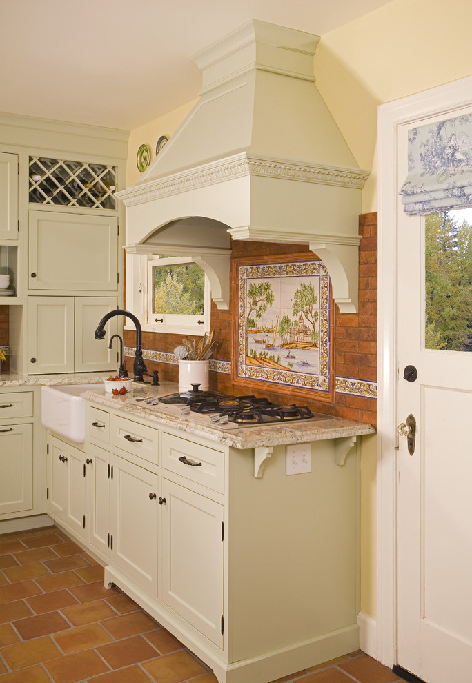 Design ideas for a country kitchen in Seattle with a farmhouse sink, recessed-panel cabinets, green cabinets, granite benchtops, multi-coloured splashback and terra-cotta splashback.