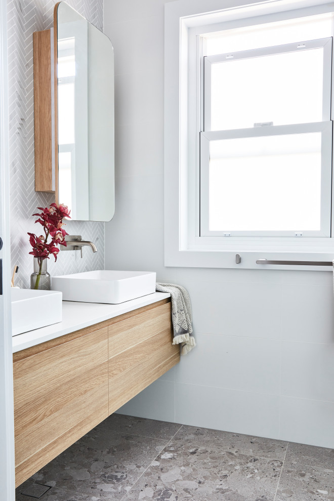 Design ideas for a scandinavian bathroom in Sydney with light wood cabinets, a freestanding tub, a one-piece toilet, white tile, ceramic tile, white walls, ceramic floors, marble benchtops, grey floor, white benchtops, a double vanity and a floating vanity.