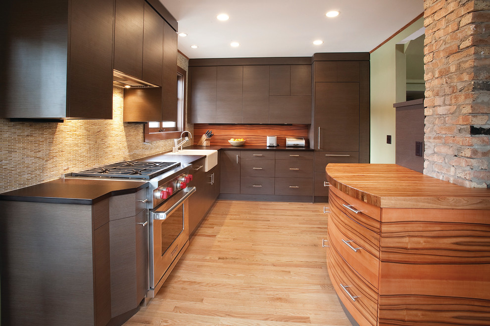 Design ideas for a modern l-shaped kitchen in Milwaukee with panelled appliances, wood benchtops, a farmhouse sink, flat-panel cabinets and brown cabinets.