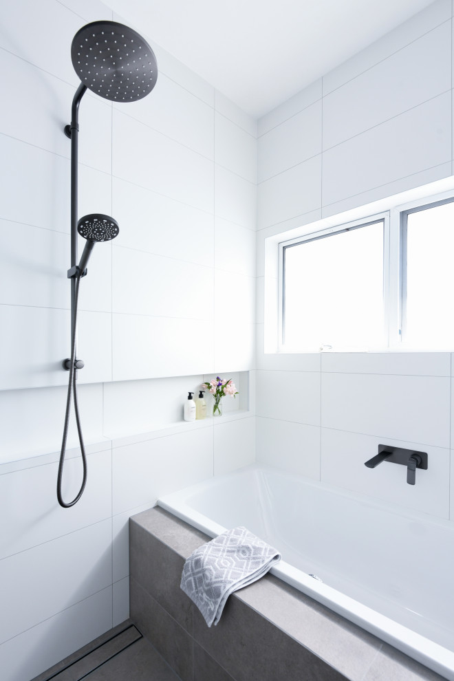 Photo of a mid-sized scandinavian master wet room bathroom in Sydney with flat-panel cabinets, medium wood cabinets, a drop-in tub, white tile, ceramic tile, white walls, ceramic floors, a drop-in sink, engineered quartz benchtops, grey floor, an open shower and white benchtops.