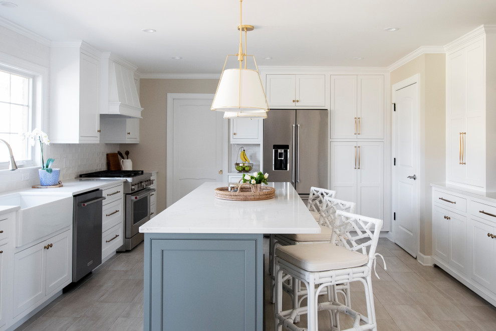 Inspiration for a large traditional u-shaped kitchen/diner in Nashville with a belfast sink, beaded cabinets, white cabinets, engineered stone countertops, white splashback, ceramic splashback, stainless steel appliances, porcelain flooring, an island, beige floors and white worktops.