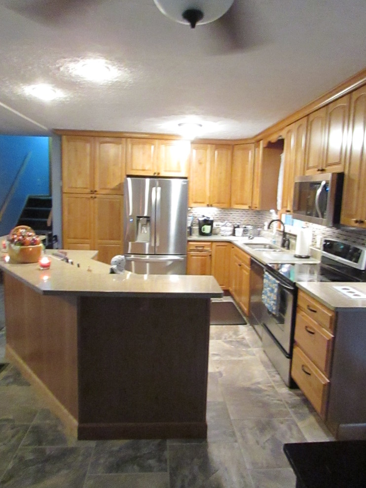 Example of a mid-sized transitional l-shaped ceramic tile eat-in kitchen design with a double-bowl sink, raised-panel cabinets, light wood cabinets, quartz countertops, multicolored backsplash, mosaic tile backsplash, stainless steel appliances and an island