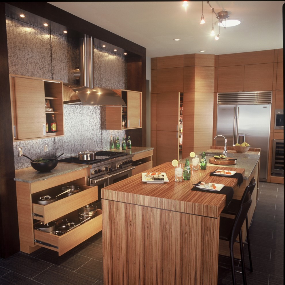 This is an example of a mid-sized asian kitchen in Raleigh with flat-panel cabinets and medium wood cabinets.