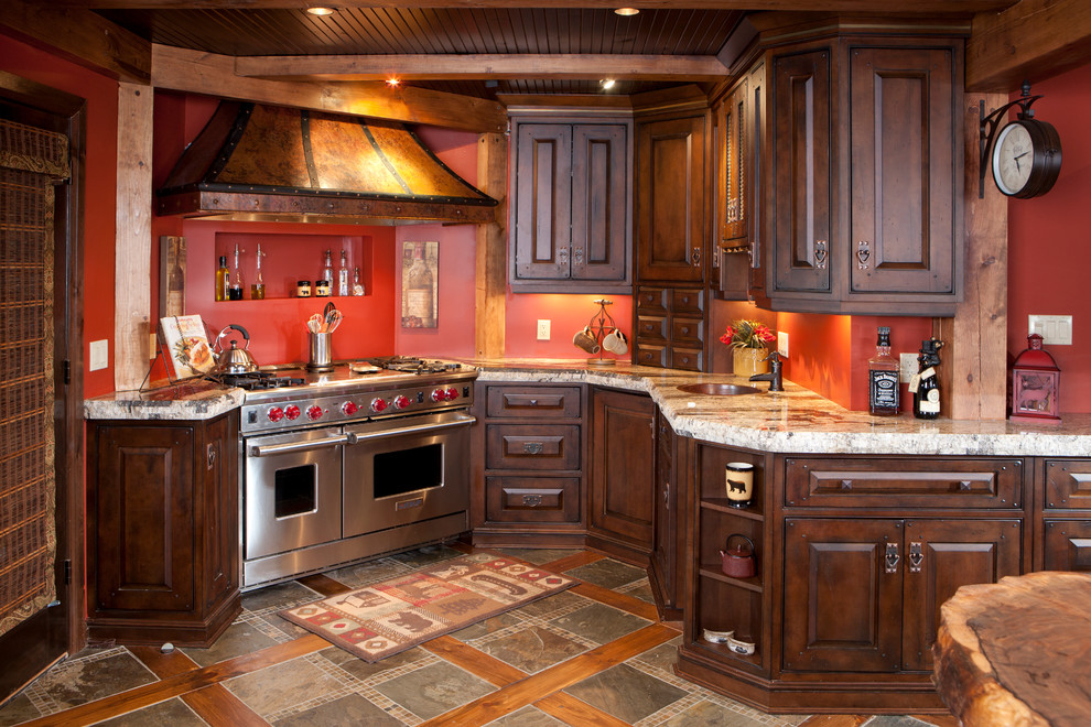 Example of a mid-sized mountain style u-shaped medium tone wood floor eat-in kitchen design in Toronto with raised-panel cabinets, distressed cabinets, granite countertops, paneled appliances and an island
