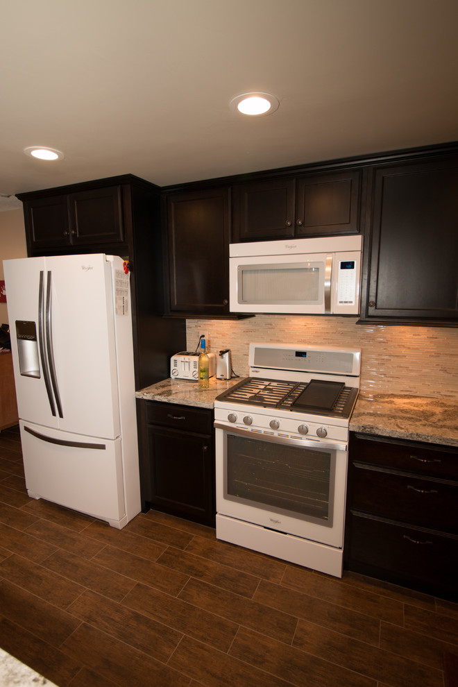 Inspiration for a mid-sized transitional l-shaped porcelain tile open concept kitchen remodel with an undermount sink, flat-panel cabinets, dark wood cabinets, quartz countertops, beige backsplash, glass sheet backsplash, white appliances and an island