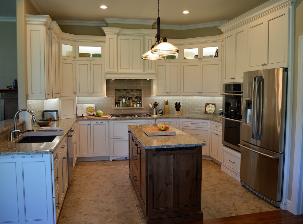 Open concept kitchen - mid-sized traditional u-shaped ceramic tile and brown floor open concept kitchen idea with beaded inset cabinets, white cabinets, granite countertops, an island, gray countertops, an undermount sink, gray backsplash, subway tile backsplash and stainless steel appliances