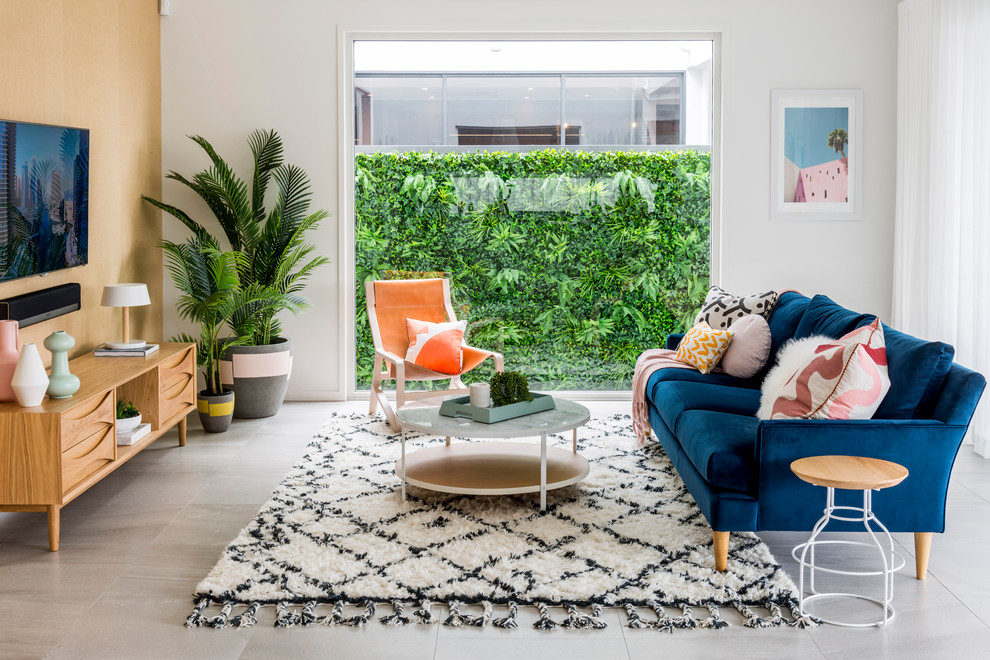 Beach style living room in Gold Coast - Tweed with white walls, a wall-mounted tv and grey floor.