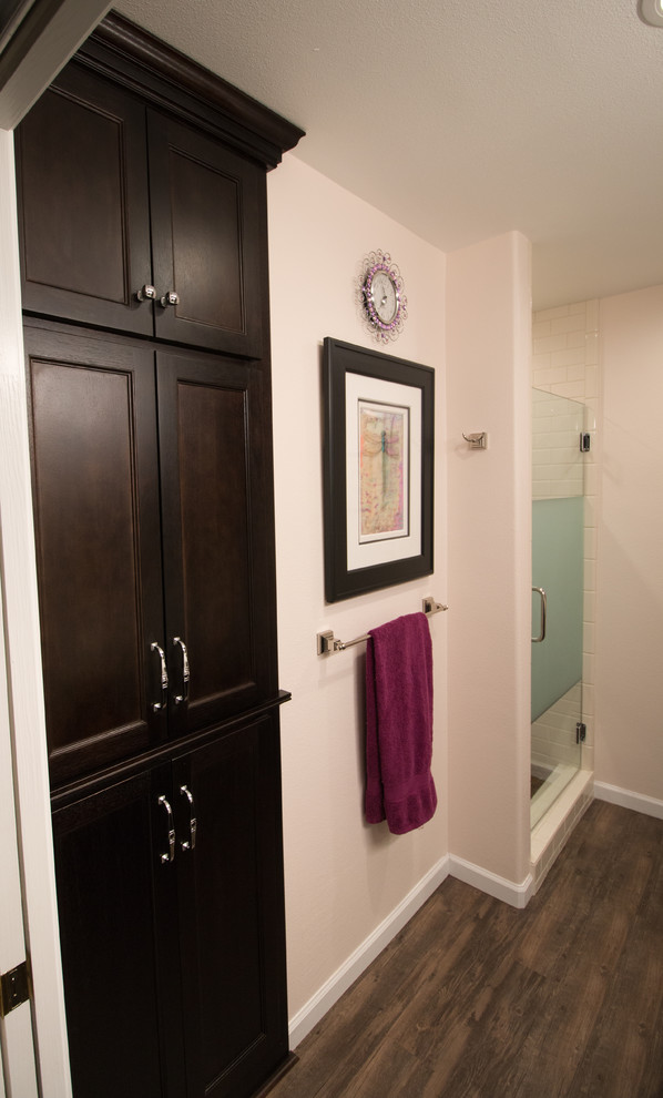 Mid-sized transitional master white tile and subway tile brown floor bathroom photo with flat-panel cabinets, dark wood cabinets, a two-piece toilet, pink walls, an undermount sink and quartz countertops