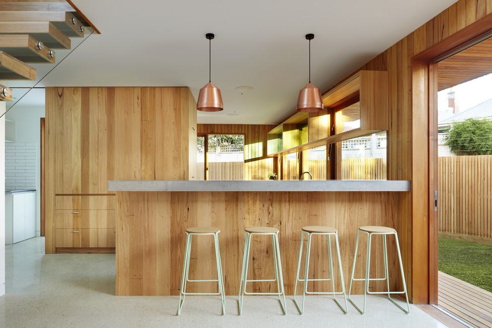 Photo of a contemporary l-shaped kitchen in Melbourne with flat-panel cabinets and light wood cabinets.