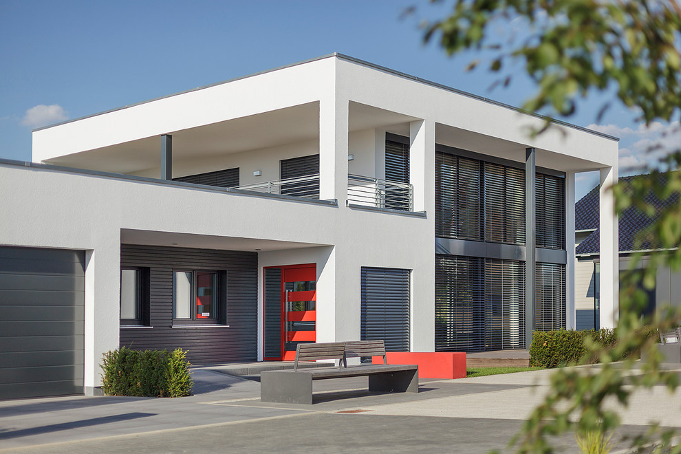 Design ideas for a large contemporary two-storey white exterior in Nuremberg with mixed siding and a flat roof.