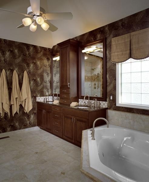 Photo of a mid-sized transitional bathroom in Kansas City with an undermount sink, raised-panel cabinets, medium wood cabinets, granite benchtops, a drop-in tub, beige tile, mosaic tile, brown walls and porcelain floors.