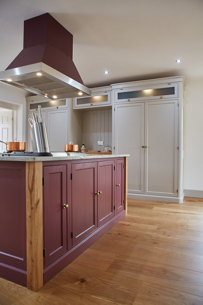 Photo of a large traditional u-shaped eat-in kitchen in Other with a farmhouse sink, shaker cabinets, purple cabinets, granite benchtops, coloured appliances, medium hardwood floors, with island, brown floor and white benchtop.