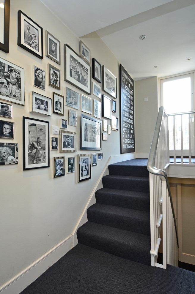 Transitional carpeted u-shaped staircase in London with carpet risers.